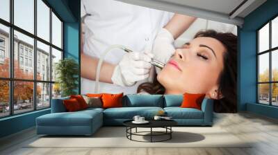 Woman getting laser face treatment in medical spa center Wall mural