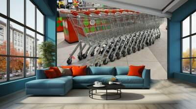 Grocery baskets are at the entrance to the store. Empty baskets in a row, supermarket interior. Wall mural