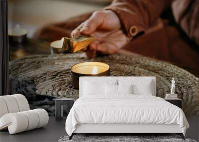 Woman hands burning Palo Santo, before ritual on the table with candles and green plants. Smoke of smudging treats pain and stress, clears negative energy and meditation wooden stick Wall mural