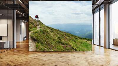 Women hiking with backpack in the mountains Wall mural