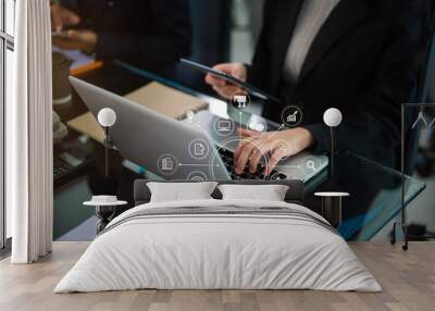 Business documents on office table with smart phone, tablet and laptop computer and graph with social network diagram and two colleagues discussing data in office. Wall mural