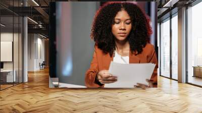 Exhausted woman next to laptop and documents, tired of overworking. Young female workaholic suffering from chronic fatigue at workplace. Wall mural