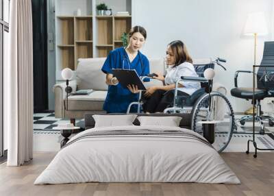 Friendly nurse doctor offering patient support during recovery. A loving caregiver taking care of her patient and showing kindness while doing a checkup in living home. Wall mural