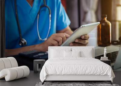 Male doctor working on desk with laptop computer and paperwork in the office. Medical and doctor concept. Wall mural