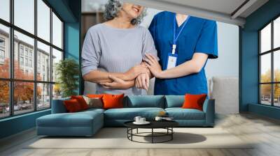 young caregiver assists her elderly woman patient at a nursing home. senior woman is assisted by a nurse at home. Wall mural