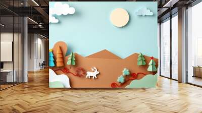 Paper craft winter scene with reindeer, trees, and clouds on a light blue background. Wall mural