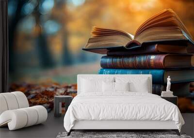 Aged books, adorned with autumn leaves, promise wisdom within their weathered pages Wall mural