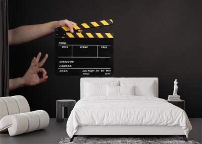 hands is holding clapper board or movie slate.It is used in video production and film industry on black background. Wall mural