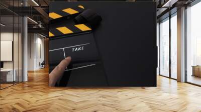 Yellow and black Clapper board or movie slate on black background and hand pointing. It use in movie and video production industry. Wall mural