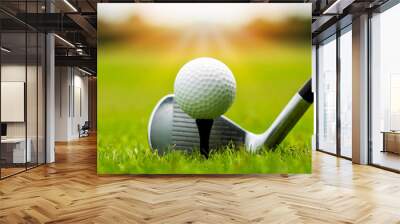 Golf club and golf ball on tee in grass in sunrise. Wall mural