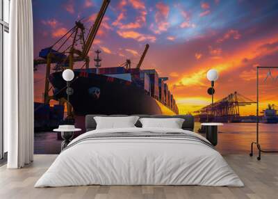 Sunset at the port with a cargo ship being loaded with containers by towering cranes Wall mural