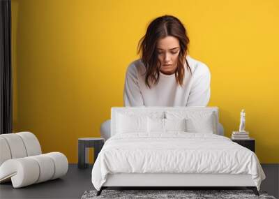 Young beautiful woman sitting with scared and stress over yellow background with sad expression covering face with hands while crying. Depression and suicide concept. Wall mural