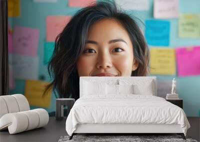 Asian woman in a creative workspace, surrounded by colorful office supplies and brainstorming ideas Wall mural