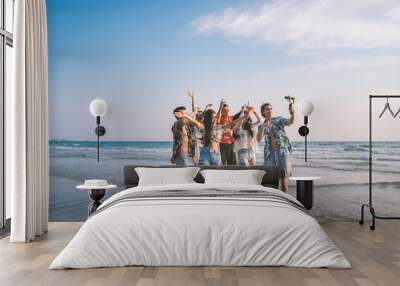 A group of happy friends having enjoy playing selfies on the beach amid the blue sky. Wall mural