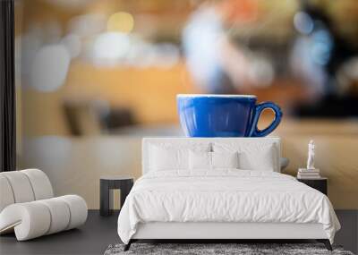 A blue cup of espresso coffee on wooden table in the background of cafeteria Wall mural