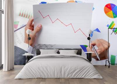 businessman observing a chart with a downward trend Wall mural