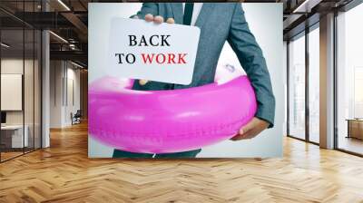 businessman with a signboard with the text back to work Wall mural