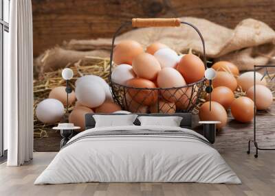 basket of colorful fresh eggs on wooden table Wall mural