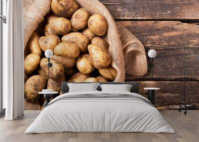 fresh potatoes in sack on wooden table Wall mural