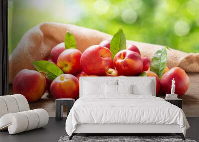 fresh ripe nectarines with leaves on a wooden table Wall mural