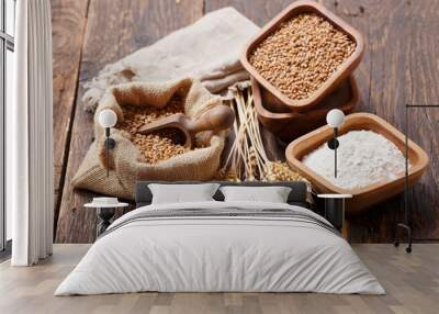 grains, flour and wheat ears on a wooden table Wall mural