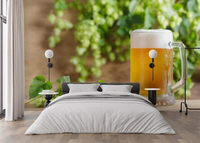 mug of beer and green hops on wooden table Wall mural