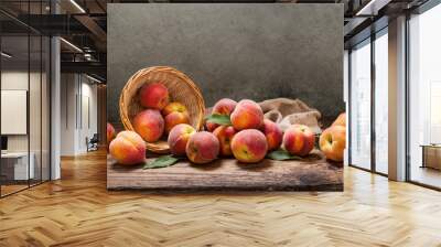 peaches with leaves in a basket on wooden table Wall mural