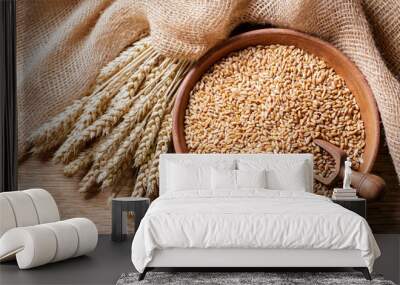 Wheat ears and grains on wooden background, top view Wall mural