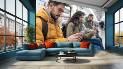 Male and female passengers using mobile phone in a metro  Wall mural