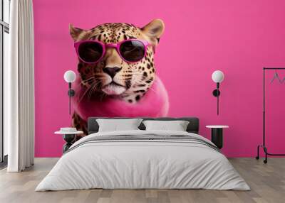 A stylish leopard wearing sunglasses against a vibrant pink background Wall mural