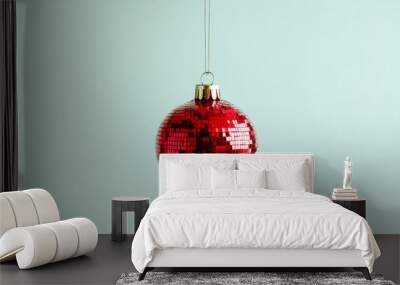 Red mirrored disco ball ornament on light green background, festive decoration concept Wall mural