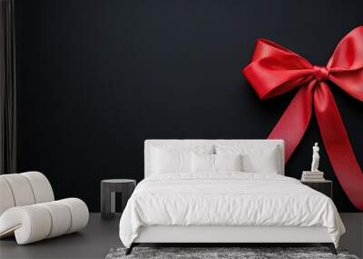 A red ribbon with a bow on a black background for birthday party or events Wall mural