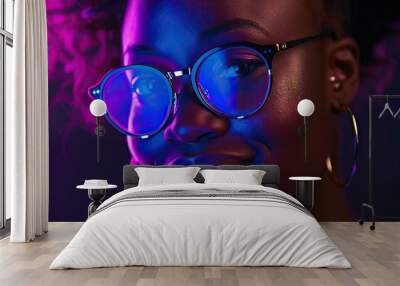 Black Woman in Dark Setting with Purple Reflection on Glasses Smiling Wall mural