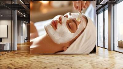 Close-up of a woman's face in a beauty salon receiving a facial treatment with white cream Wall mural