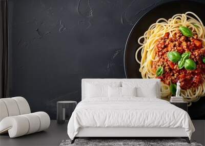 Top view of a gourmet spaghetti bolognese dish on a sleek black plate Wall mural