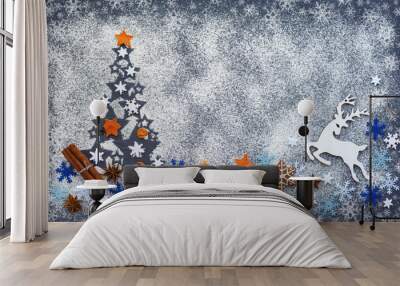 Christmas tree made from flour on a black background with snowflakes, deer,  anise stars, cookies and cinnamon, white flour looks like snow. Top view. Space for your text. Wall mural