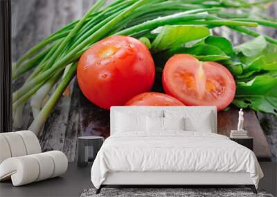 Tomatoes with onions and arugula on a wooden board Wall mural