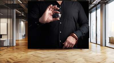 man in a black shirt holds a stone ball for religious rituals, meditations Wall mural