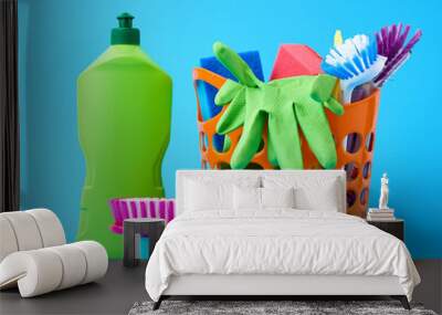 orange basket with washing sponges, rubber protective gloves, brushes and cleaning agent in a green plastic bottle Wall mural