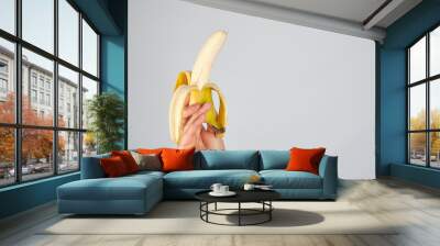 peeled fresh banana in female hand Wall mural