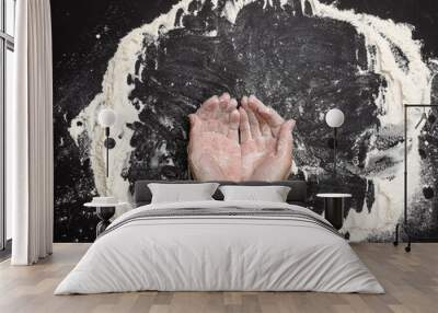 Sifted white wheat flour on a black table and two female hands, top view. cooking at home Wall mural