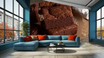 stack of baked square pieces of chocolate brownie cake on brown parchment paper Wall mural