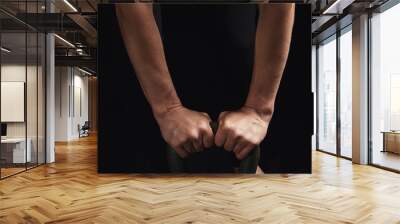 two female hands hold the handle of an iron kettlebell Wall mural