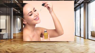 Closeup shot of cosmetic oil applying on young woman's face with pipette. Beauty therapy concept. Wall mural