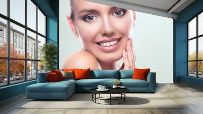 Closeup shot of young beautiful woman face portrait with healthy skin. Pretty girl smiling to you Wall mural