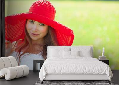 Pretty girl wearing red hat posing outdoors Wall mural