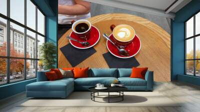 Two cups of coffee with latte art on wooden table Wall mural