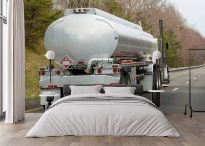 Rear view of fuel truck on highway with trees in background. Wall mural