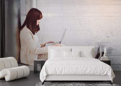 Businesswoman in high heels sitting on floor with computer in her lap Wall mural