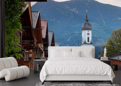 Row of typical German houses with wooden balconies in historic center of Garmisch with domed parish church St Martin and Wank mountain of Bavarian Prealps, Garmisch Partenkirchen Bayern Germany Europe Wall mural